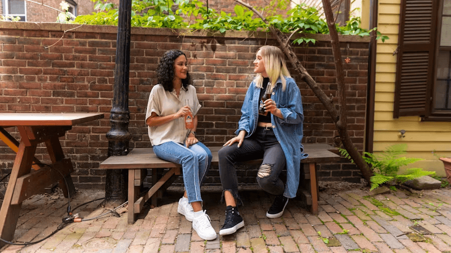 Two neighbours chatting on a bench outside